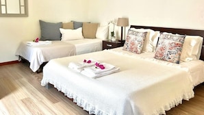 A hotel room with two beds, a nightstand, a lamp, and a mirror.