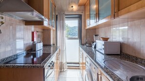 Eine moderne Küche mit Granit Arbeitsplatten, Holzschränken und Blick ins Freie.