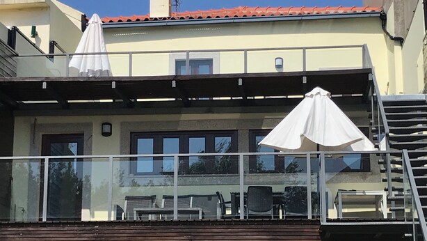 Rakennuksessa on parveke, ulkotila istumista varten ja satelliittiantenni.