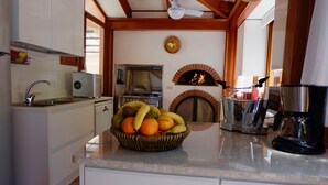 A kitchen with a stone countertop, a fruit bowl, a coffee maker, a stove, and a pizza oven. - Lovely 6 Bedrooms Villa With Pool, Located few Minutes From Sorrento Center (Sorrento)