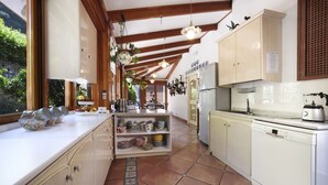 A kitchen with wooden beams, white cabinets, a tiled floor, and hanging plants. - Lovely 6 Bedrooms Villa With Pool, Located few Minutes From Sorrento Center (Sorrento)