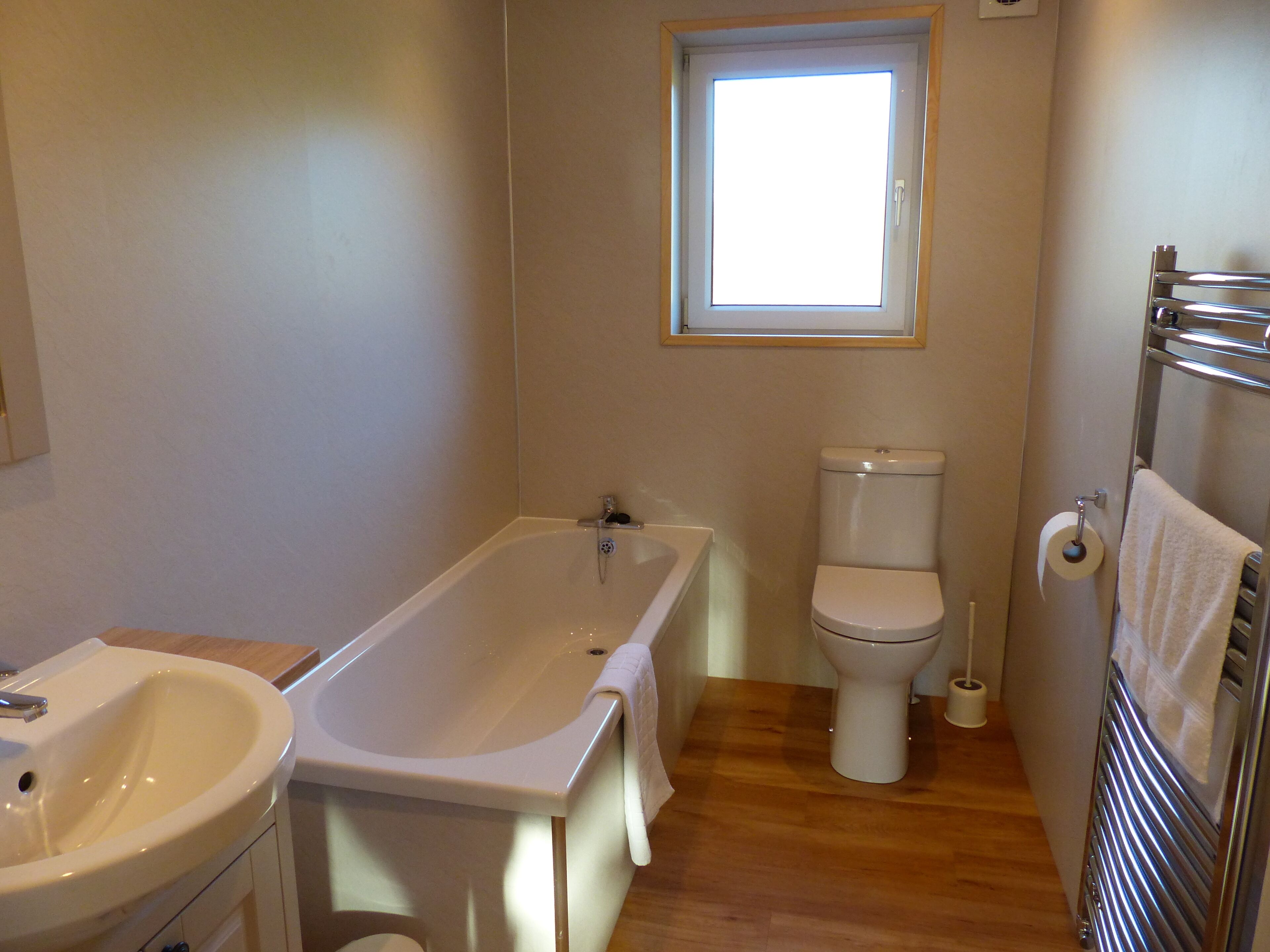 A bathroom with a bathtub, toilet, and sink.