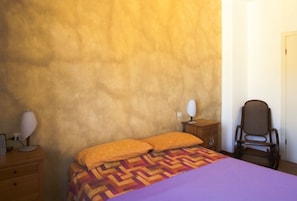 A bedroom with a bed, two bedside lamps, a chair, and a wooden nightstand. - Apartment of 160 square meter in strategic position any destination in 15 minute (Milano)