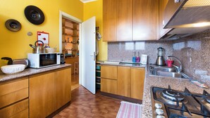 A kitchen with wooden cabinets, a microwave, a gas stove, and a sink.