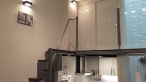 A modern kitchen with stainless steel appliances, a glass staircase, and a view of the outdoors. - Interior design and exclusive design (Sevilla)