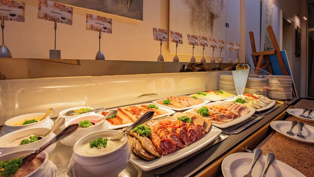 A buffet with various food items and a painting on the wall. - Seehotel Grossraeschen (Großräschen)