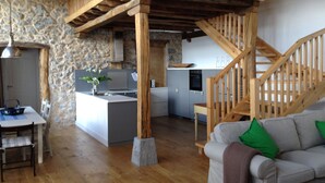 A spacious living area with a wooden staircase, a kitchen, and a dining area. - Mountain and Sea, The Basque Country (Gardata Artika (Bizkaia))