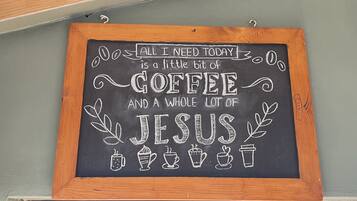 A chalkboard sign with a humorous message about needing coffee and Jesus.