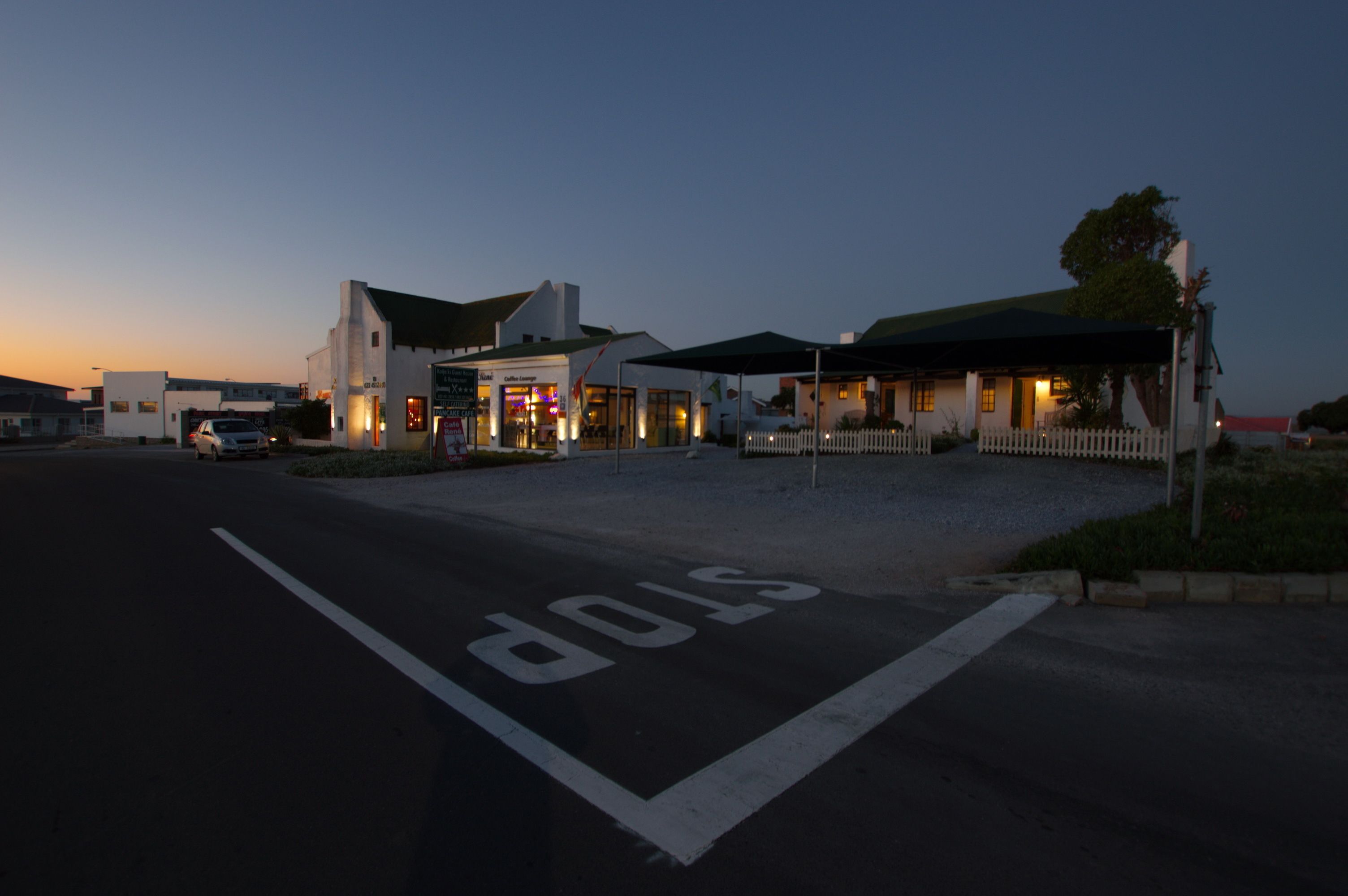 A building with a stop sign painted on the road in front.