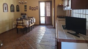 A spacious kitchen with a dining area, featuring a tiled floor, wooden cabinets, and a chandelier. - ✭Autonomous villa of recent construction in the island of Favignana (EGADI) (Favignana)