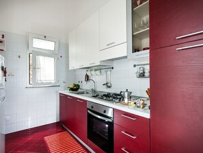 Kitchen features a stainless steel range hood, oven, and double sink, with a window above the sink.