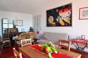 Cozy living space with a dining area, sofa, and bookshelf, perfect for relaxing and enjoying a meal.