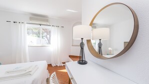 Ein Hotelzimmer mit einem Bett, einem Schreibtisch, einem Spiegel und einem Vorhangfenster.