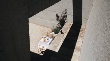 A table set outdoors with a potted plant and a chair.
