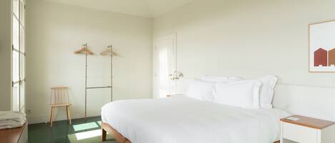 A bedroom with a wooden bed, a bedside table, a chair, and a wardrobe.