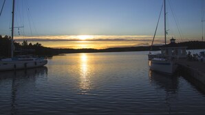 A calm lake at sunset with two boats docked on the shore. - Nice old style cottage close to the Baltic Sea (Gryt, Valdemarsvik)