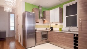Une cuisine moderne dotée d’un réfrigérateur en acier inoxydable, de meubles en bois, d’un four encastré et d’une fenêtre offrant une belle vue.
