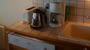 Une cuisine équipée d’un four à micro-ondes, d’un grille-pain, d’une bouilloire et d’une machine à café.