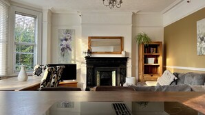 A living room with a fireplace, a sofa, a coffee table, and a bookshelf.