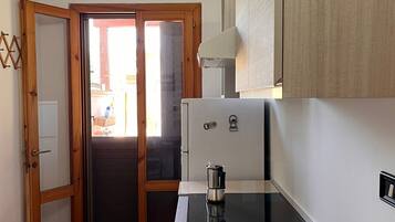 Frigorifero, pentole/stoviglie/utensili, spezie, tavolo da pranzo