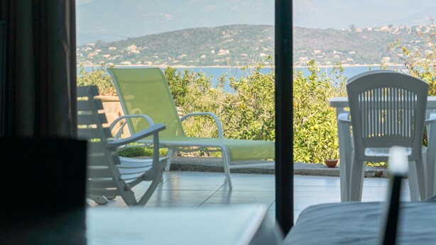 A terrace with two chairs and a table, overlooking a scenic view of a lake and distant hills. - Coti Chiavari: House / Villa - Coti-chiavari (Coti-Chiavari)