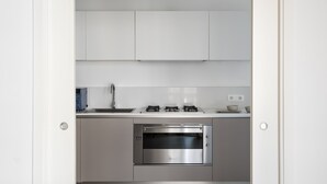 A modern kitchen with white cabinets, a stainless steel oven, and a countertop with a sink and stove. - Design and Comfort in the Heart of Catania by Wonderful Italy (Catania)