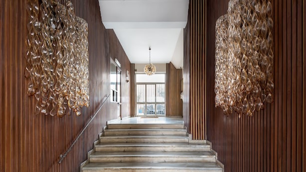A staircase with wooden paneling and a chandelier. - Design and Comfort in the Heart of Catania by Wonderful Italy (Catania)