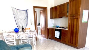 Ein Wohnzimmer mit einer großen Couch und einem Essbereich mit Tisch und Stühlen.