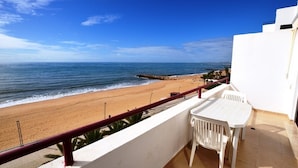 Ein Balkon mit Blick auf Strand und Meer.