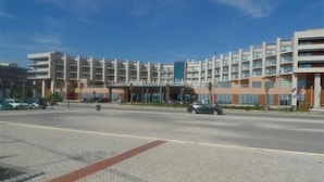 Un hotel de varios pisos con un diseño moderno, que cuenta con un atrio central y múltiples balcones.