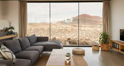 Minimalistinen talo, jossa on lämmitetty uima-allas ja upea tulivuori