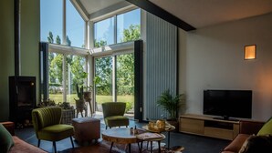 En moderne stue med stort vindue, pejs, fjernsyn og sofa.
