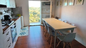 A modern kitchen with a dining area, a view through a glass door, and a tiled floor. - Lerici, Portovenere, 5 terre... all the wonders just a few minutes from the house! (Lerici)