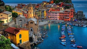A coastal town with colorful buildings, a prominent church, and a stone fortification. - Lerici, Portovenere, 5 terre... all the wonders just a few minutes from the house! (Lerici)