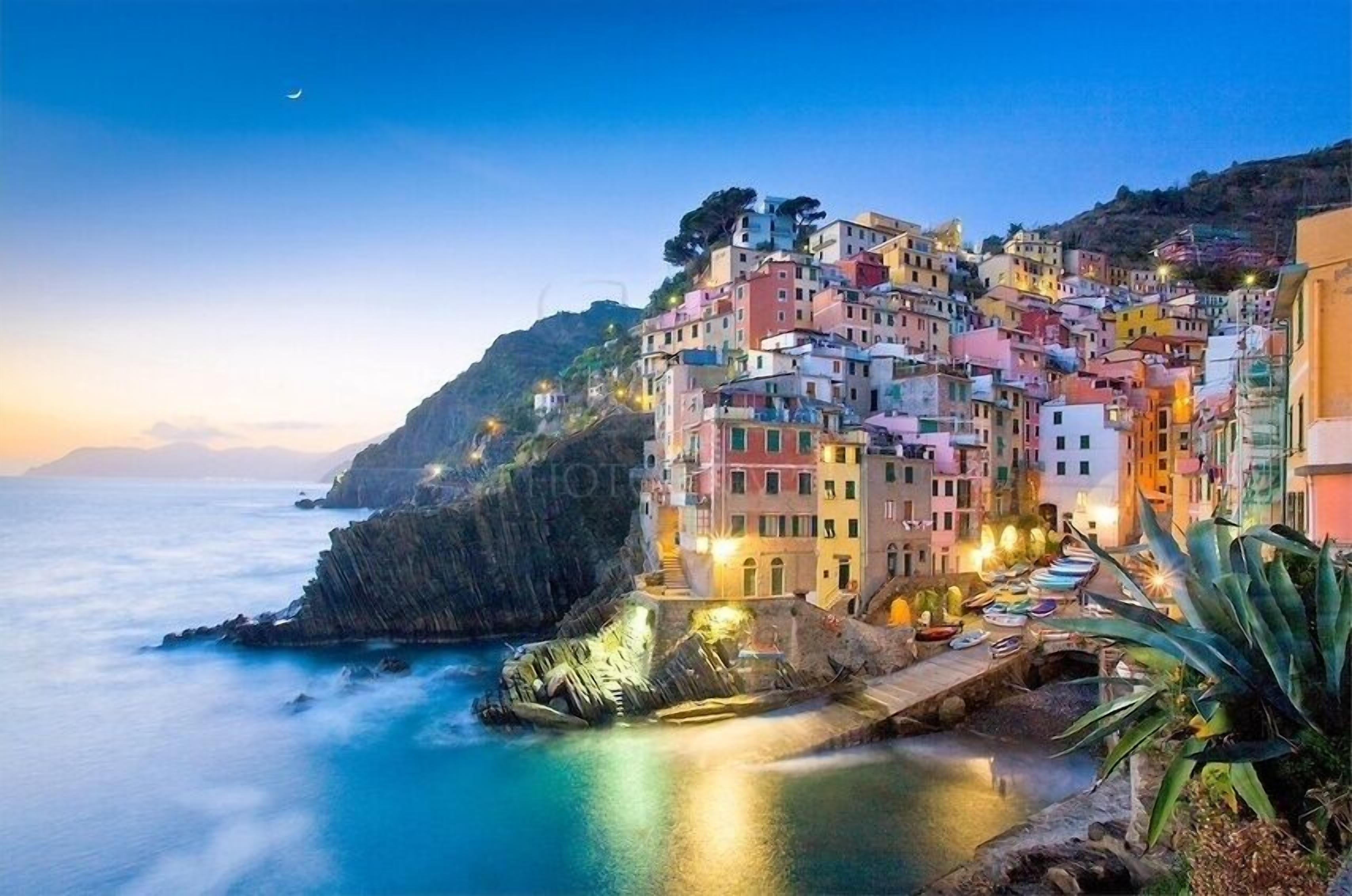 Une ville côtière aux bâtiments aux couleurs vives, dotée d’un littoral rocheux et bordée d’une mer calme.