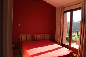 Enjoy a restful stay in this cozy room featuring a single bed, a window with curtains, and a balcony.