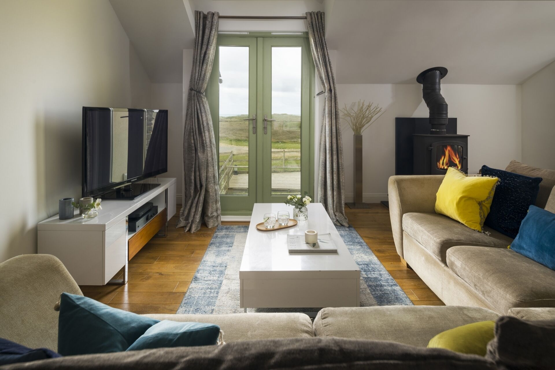 Een woonkamer met een bank, een salontafel, een televisie en een open haard.