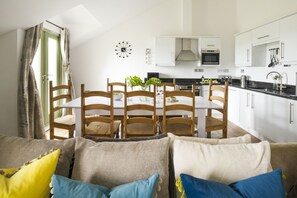 A modern kitchen with white cabinets, a black countertop, and stainless steel appliances.