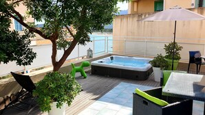 A rooftop terrace with a hot tub, seating, potted plants, and a view of the sea. - house / villa - Algajola (Algajola)