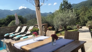A terrace with lounge chairs, a pool, and a view of mountains. - Villa with private pool in Tuscany (Tresana)