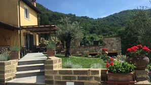 A stone staircase leading to a yellow building with a covered patio area. - Villa with private pool in Tuscany (Tresana)