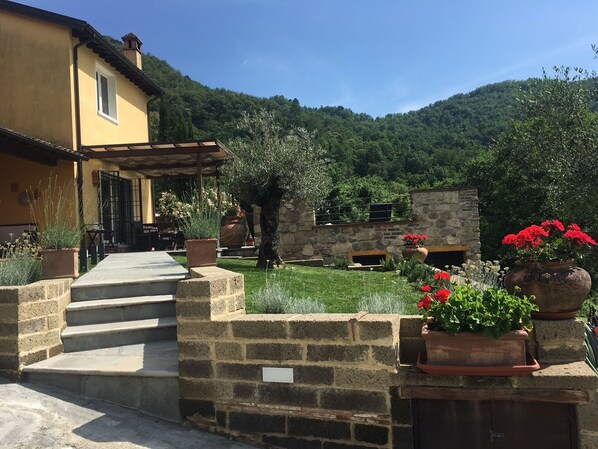 A stone staircase leading to a yellow building with a covered patio area.