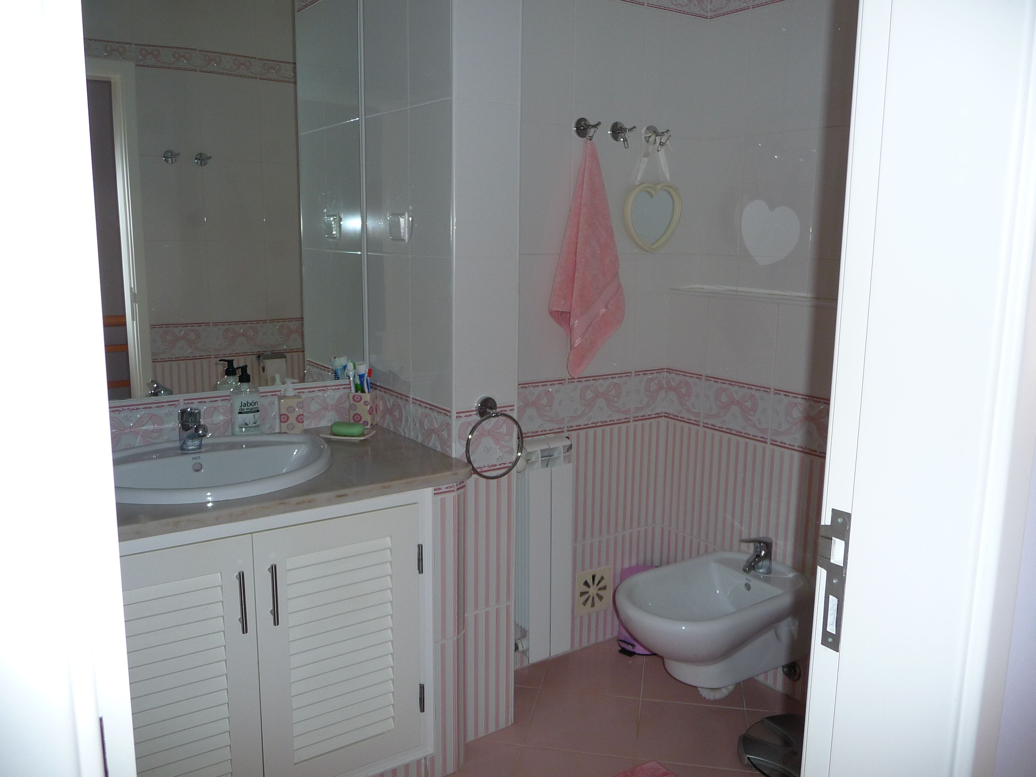 A bathroom with a sink, mirror, vanity, and bidet.