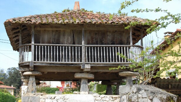 Ein hölzernes Pavillon mit einem Ziegeldach und einem Balkon.