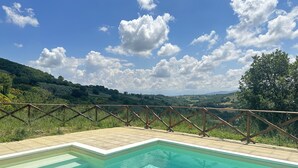 Una piscina con cubierta de madera y vista a un paisaje montañoso.