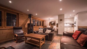 A cozy living room with a fireplace, leather sofas, and a dining area.