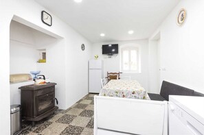 Cozy retreat with a bed, wardrobe, kitchenette, and TV.