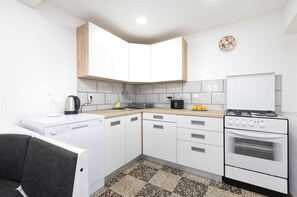 Compact kitchen with stove, sink, and ample counter space for cooking and preparing meals.