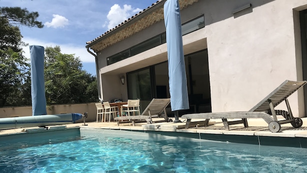 A swimming pool with clear water, surrounded by lounge chairs and a table. - At the top of the village, magnificent view of Mt Ventoux, private heated swimming pool (Bédoin)