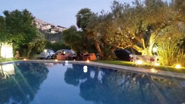 A swimming pool with surrounding greenery and outdoor seating.